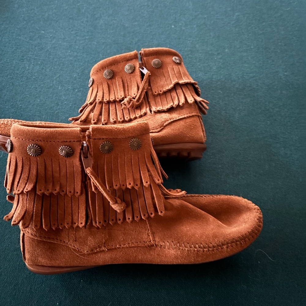 Minnetonka sz 7 moccasins with fringe, side zipper and thick grip rubber sole.